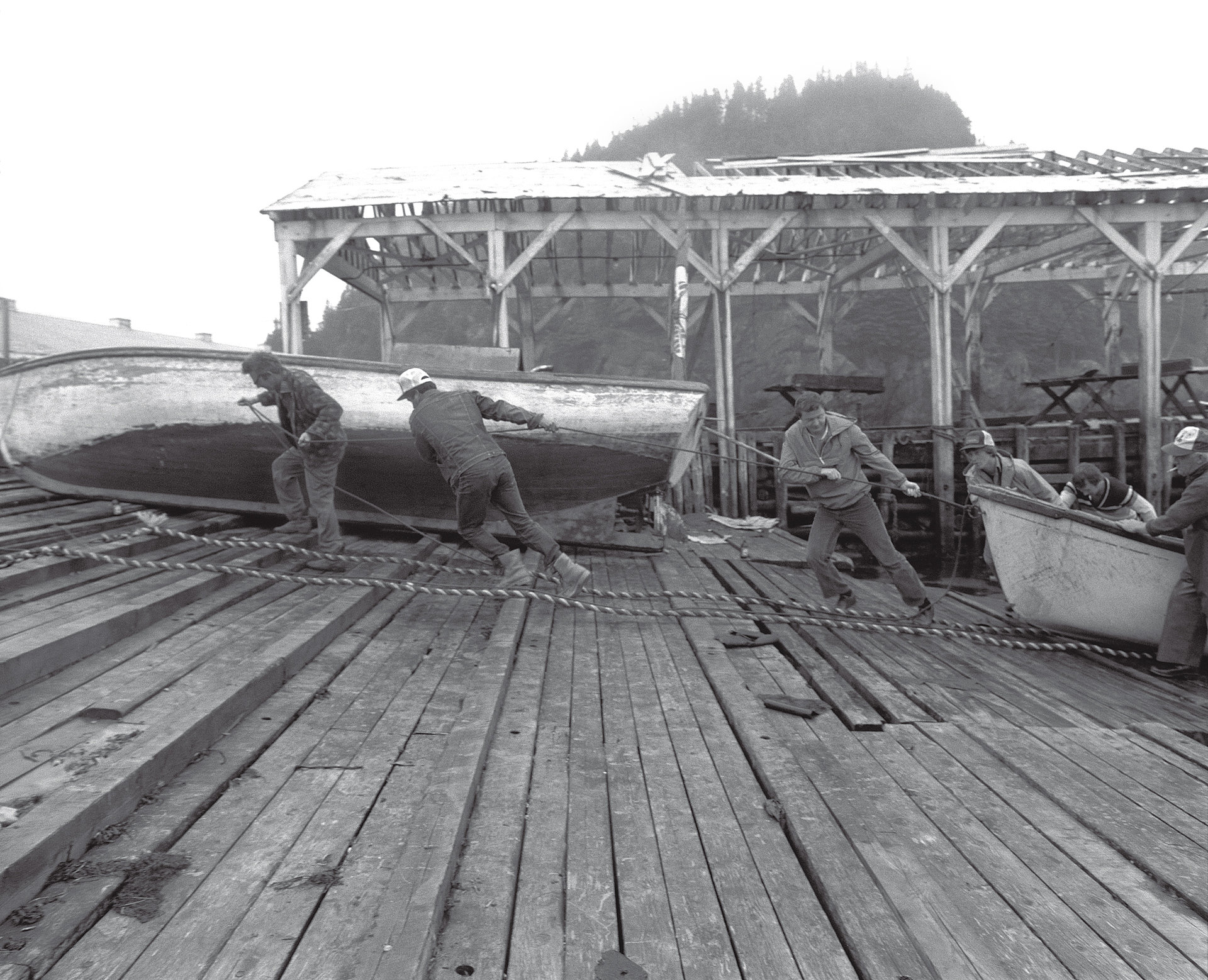 Fischer ziehen Boote vor einem Sturm an Land, Bay Bulls, Newfoundland, Kanada 1982